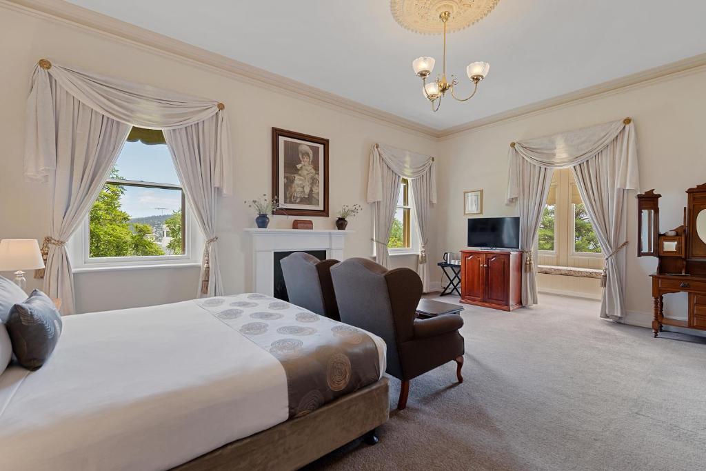 a bedroom with a bed and a chair and a television at Waratah On York in Launceston