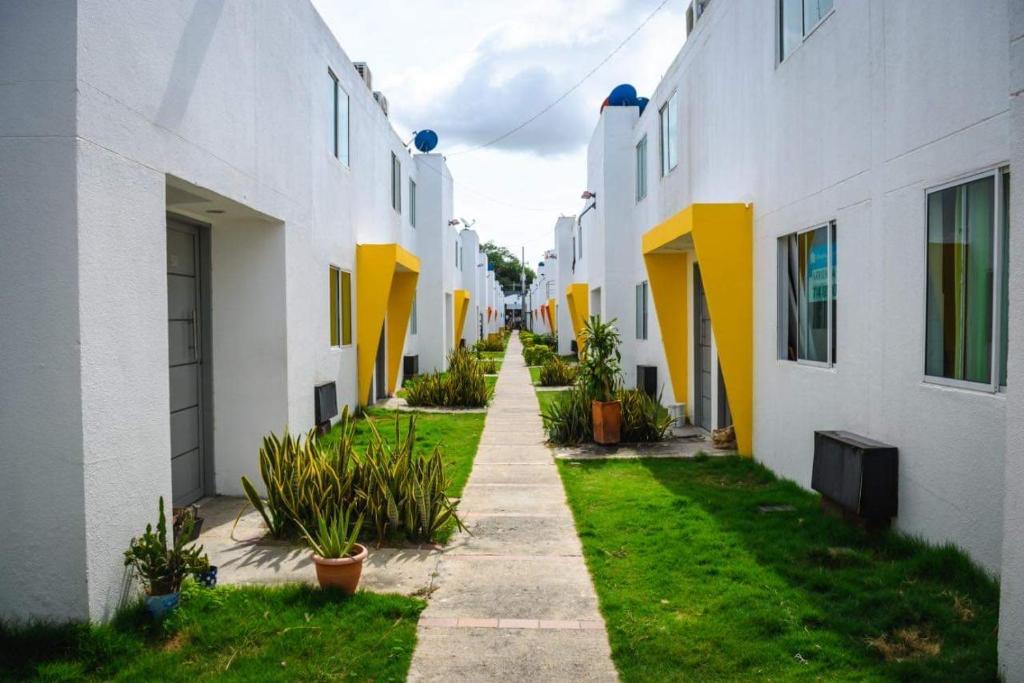 une allée entre deux bâtiments blancs et jaunes dans l'établissement CIC Apartamento amoblado Mirador del Sinú, à Montería