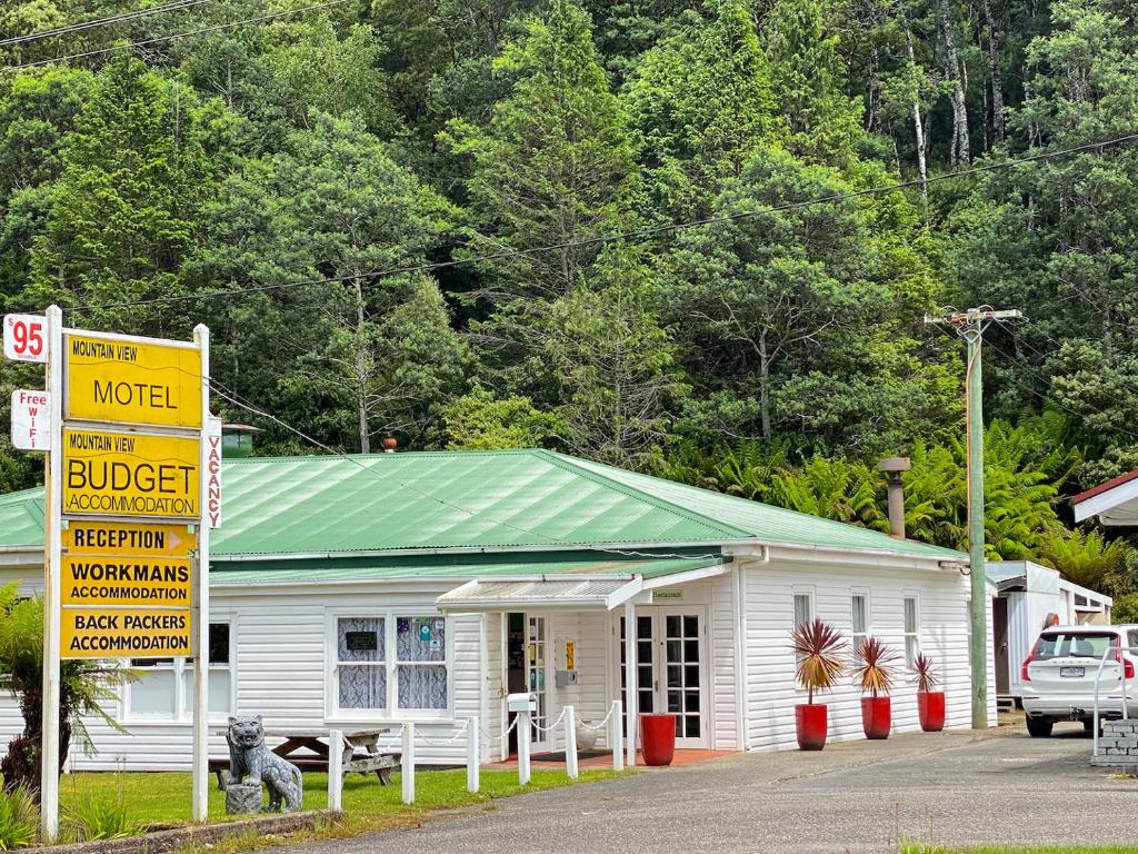 un edificio con una señal amarilla delante de él en Mountain View Motel, en Queenstown