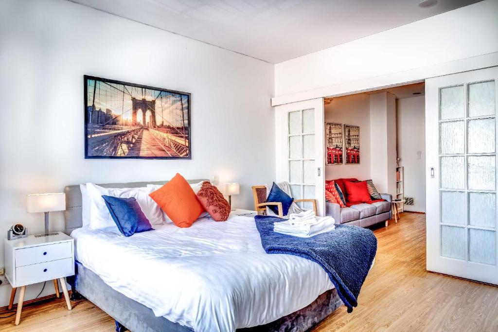 a bedroom with a large bed with orange and blue pillows at 405 Charming Central renovated lift sleep 4 in Perth