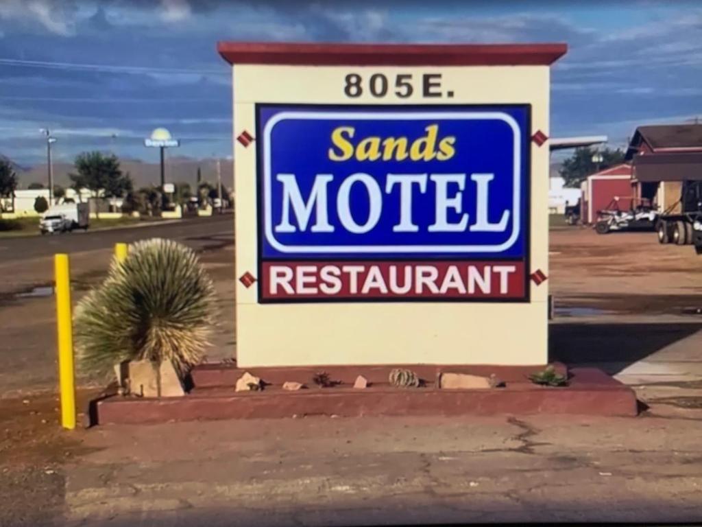 una señal para un motel de Santa en un estacionamiento en Sands Motel, en Van Horn