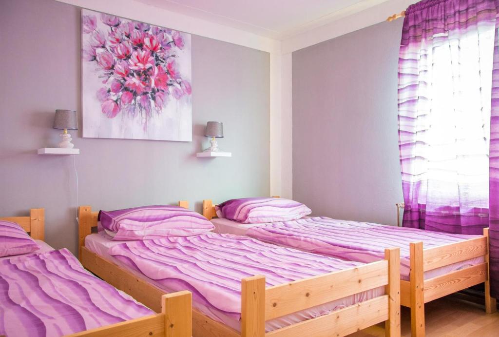two beds in a bedroom with pink sheets at Discover the magic of nature in Slani Dol