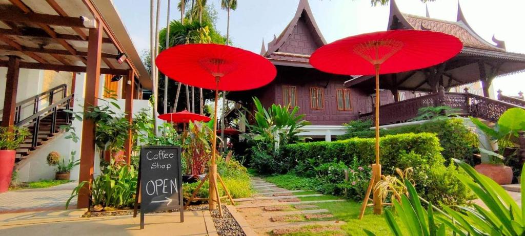 a group of red umbrellas in front of a house at Baan Veanglhek Residence in Phra Nakhon Si Ayutthaya