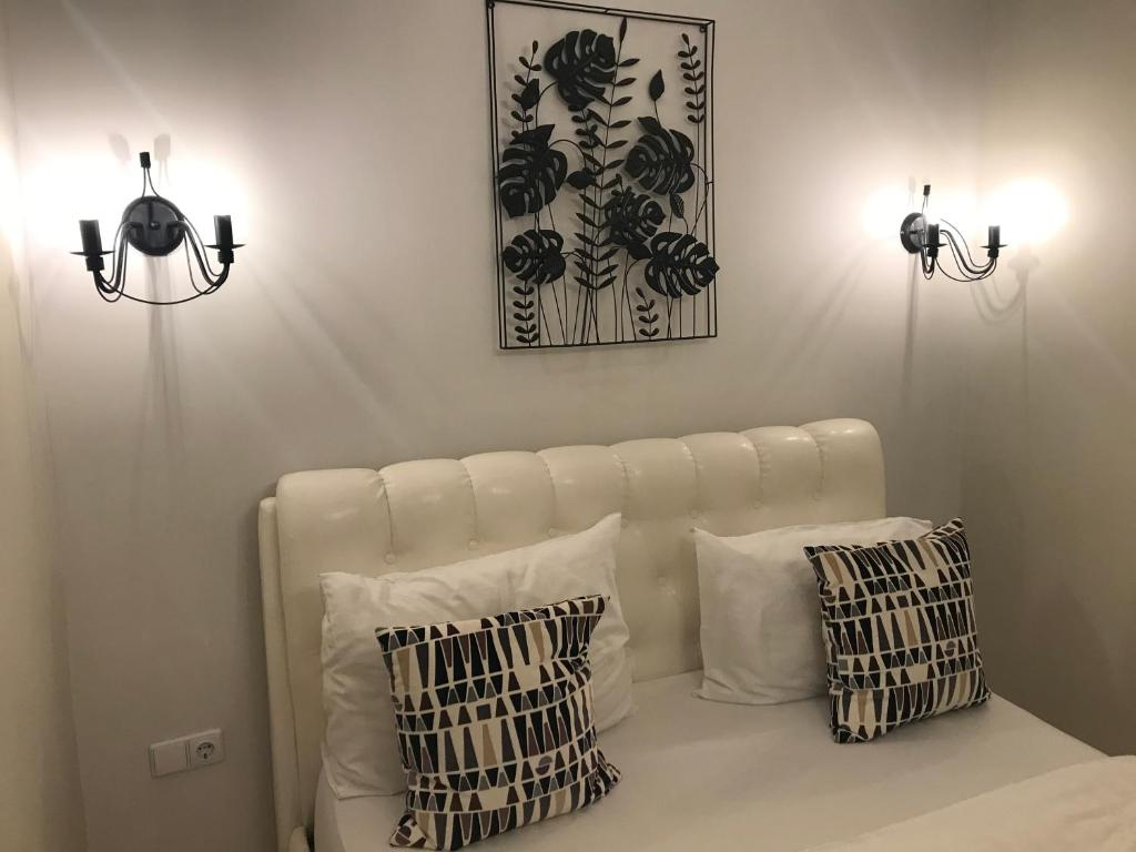 Sofá blanco con 2 almohadas y 2 luces en Luxury Old Town apartment, en Vilna