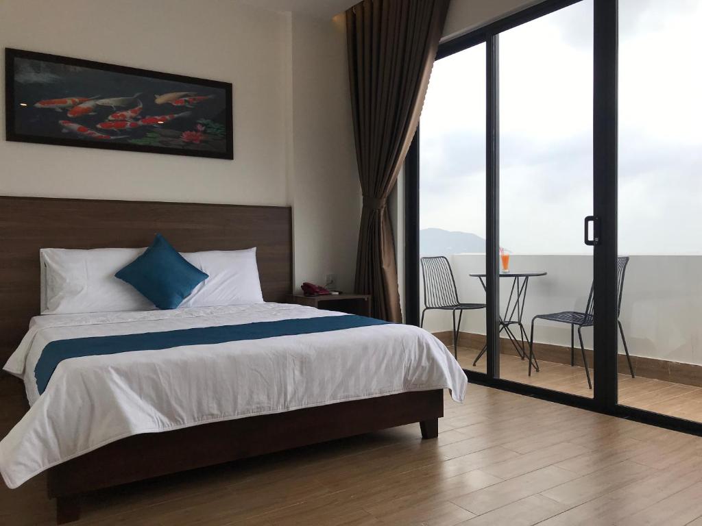 1 dormitorio con 1 cama y balcón con mesa en Hotel Hoàng Hưng Quy Nhơn, en Quy Nhon