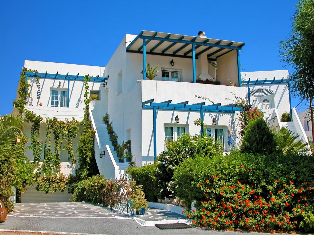 un gran edificio blanco con flores delante en Mimoza, en Adamas