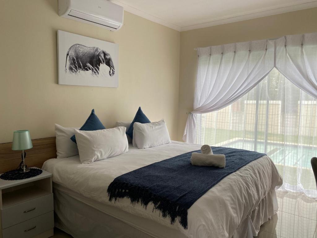 a bedroom with a bed with a stuffed elephant on it at iMpongo Royal Lodge in Richards Bay