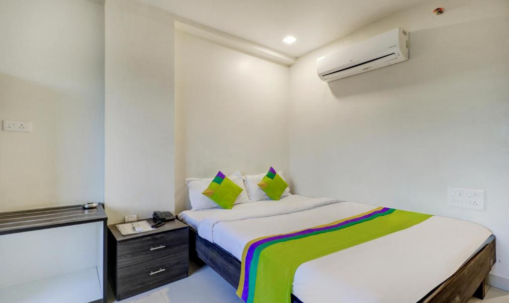 a small bedroom with a bed and a dresser at Treebo Trend Orange City in Nagpur