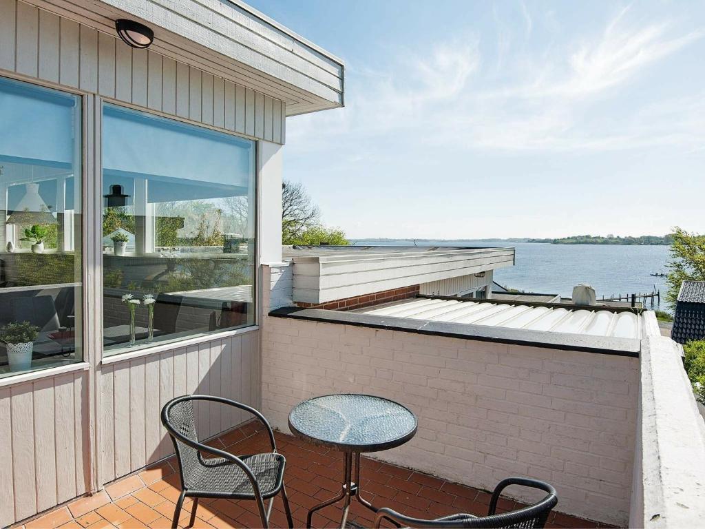 a patio with two chairs and a table on a house at 4 person holiday home in Gr sten in Gråsten