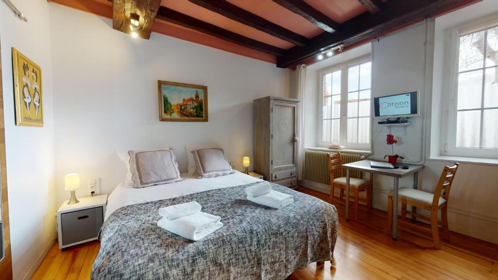 a bedroom with a bed and a table and chairs at Le Clos bartholdi in Colmar