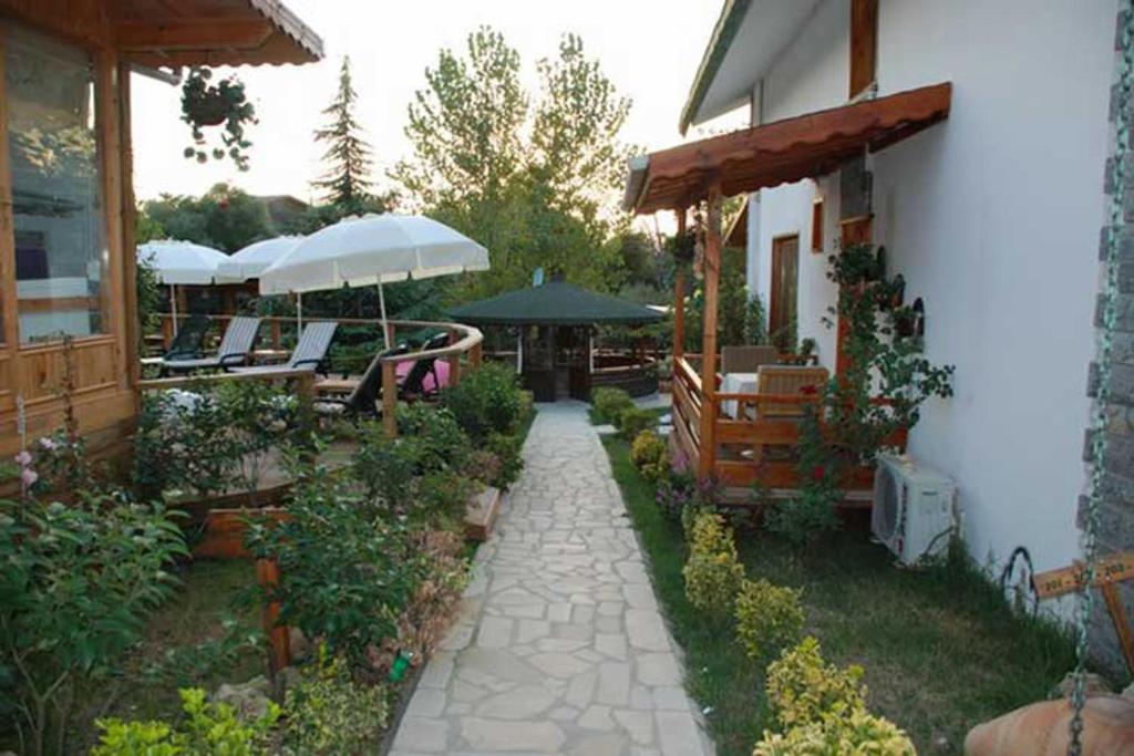 a patio with chairs and umbrellas on a house at Treetops Park Hotel in Şile