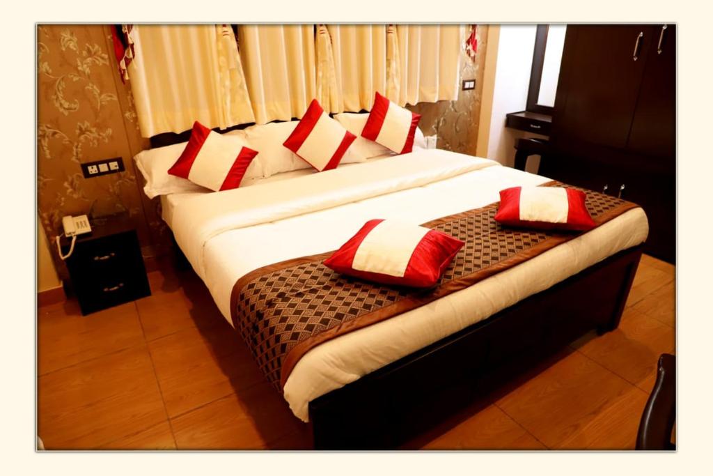 - une chambre avec 2 lits dotés d'oreillers rouges et blancs dans l'établissement The Ranikhet Continental, à Rānīkhet