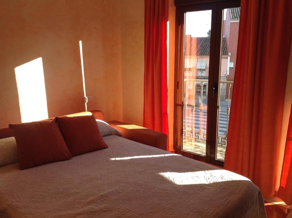 Un dormitorio con una cama y una ventana grande. en Hotel Julio, en Trujillo