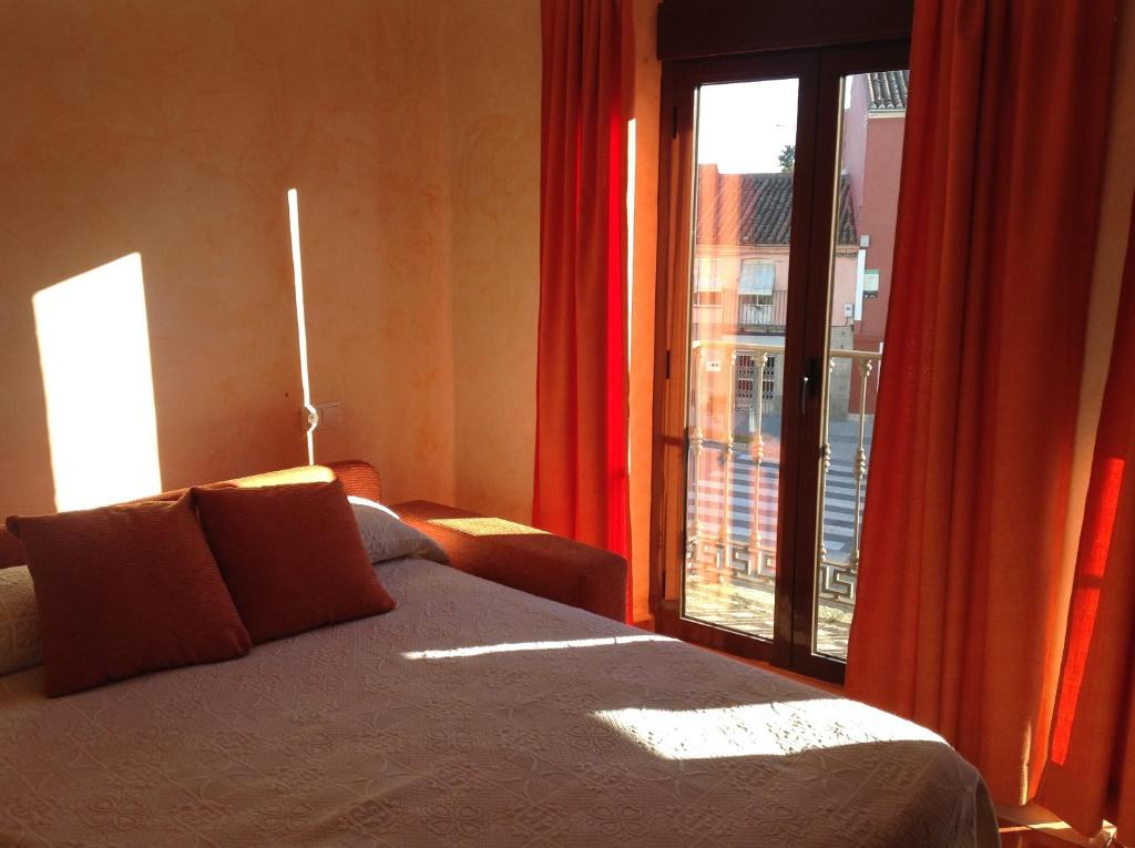 a bedroom with a bed and a large window at Hotel Julio in Trujillo