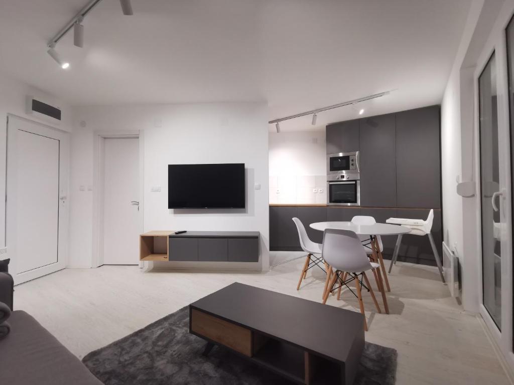 een witte woonkamer met een tafel en een tv bij Crni bor in Divčibare