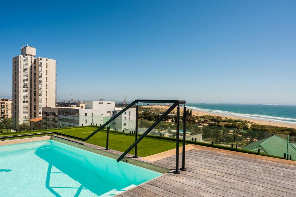 einen Pool auf einem Balkon mit Blick auf den Strand in der Unterkunft Paxton Luxury Apartments self-catering in Port Elizabeth
