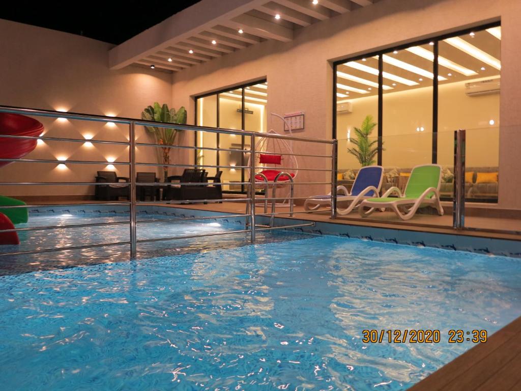 una gran piscina en un edificio con sillas en استراحة منتجع بالى, en Yeda