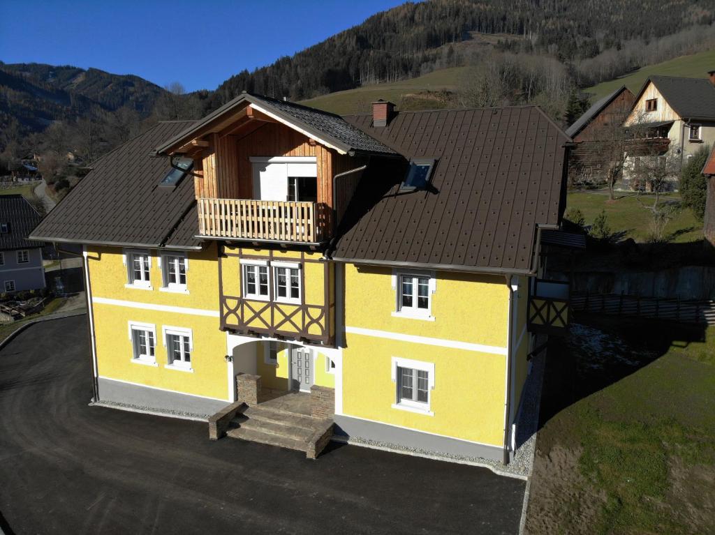 une maison jaune avec un balcon au-dessus dans l'établissement Gästezimmer Gombotz, à Etmissl