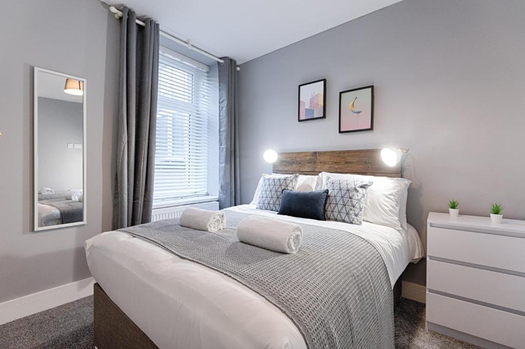 Un dormitorio con una cama grande y una ventana en Murray Nest #2 - TV in Every Bedroom! en Llanelli