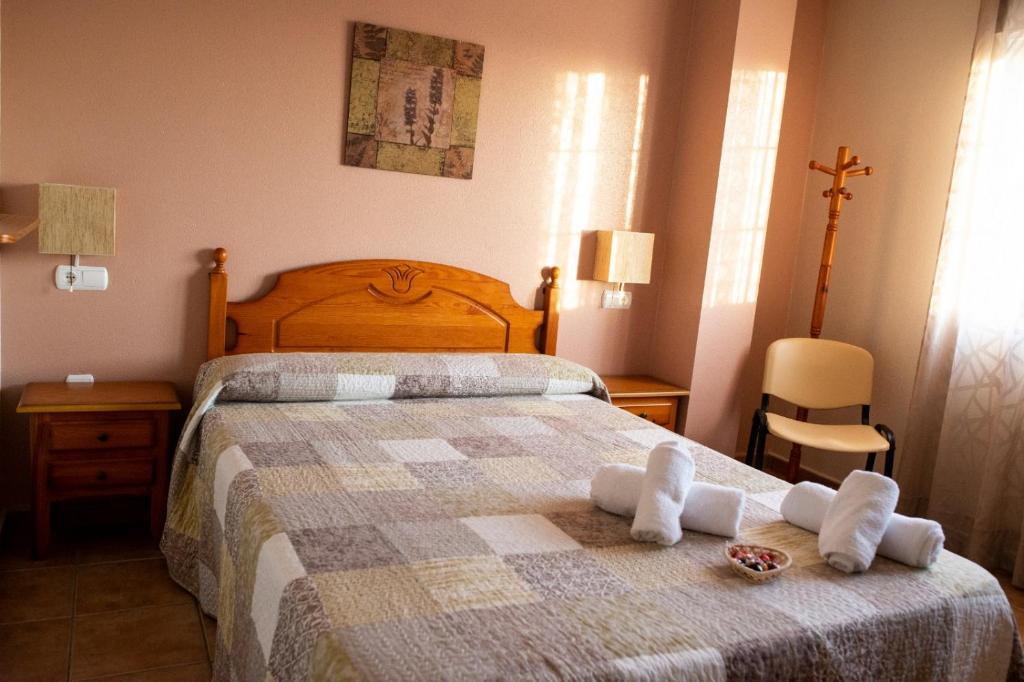 una camera da letto con un letto e asciugamani di Pensión El Cordobés a Los Alcázares