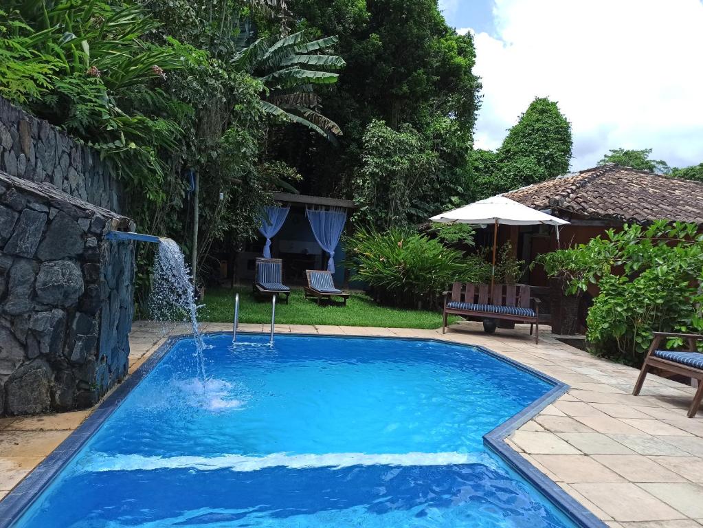 uma piscina com uma fonte em um quintal em Pousada Encantos do Mar em Arraial d'Ajuda