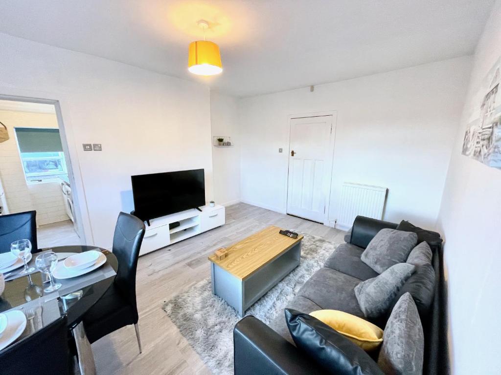 a living room with a couch and a table at Kingsbridge Apartment in Glasgow