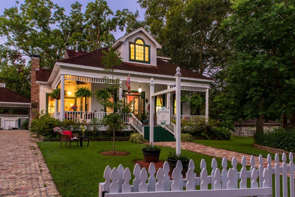 una cerca blanca frente a una casa en White Oak Manor Bed and Breakfast, en Jefferson