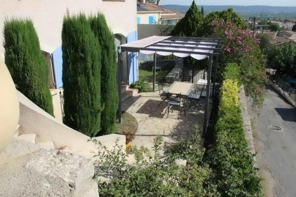 an outdoor patio with a table and an umbrella at RdC-villa_2Pieces 35m2_domine la plaine entre NIMES_CEVENNES_MER in Calvisson