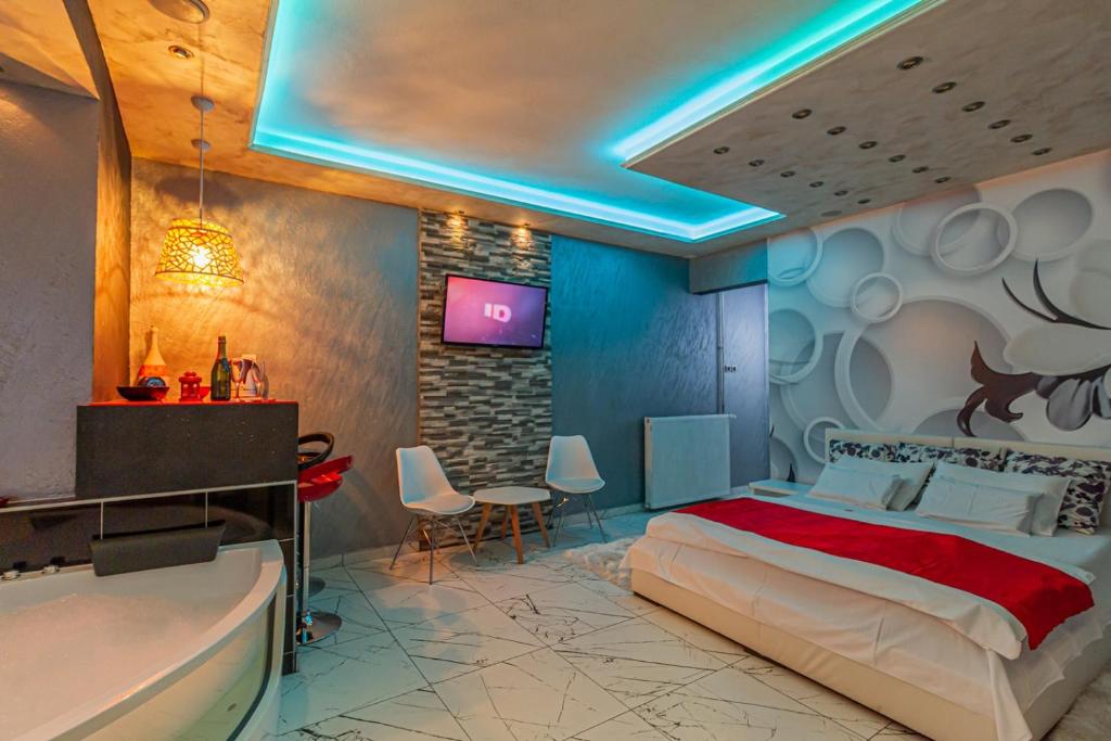 1 dormitorio con cama, bañera y TV en Apartments Blue House, en Zlatibor