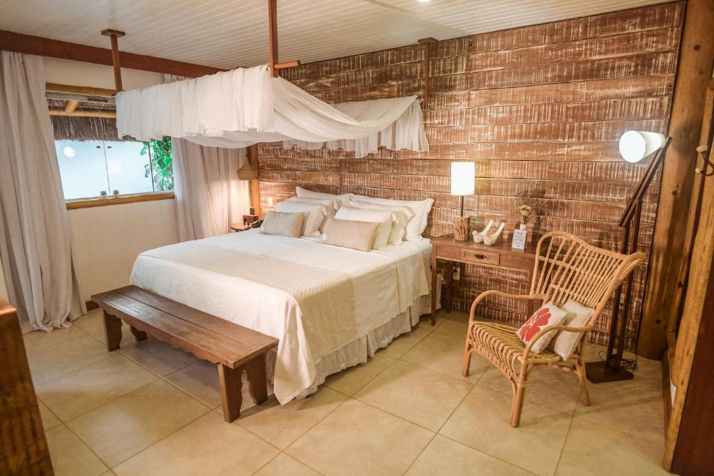 um quarto com uma cama grande e uma parede de madeira em Ecocharme Pousada do Marcilio em Fernando de Noronha