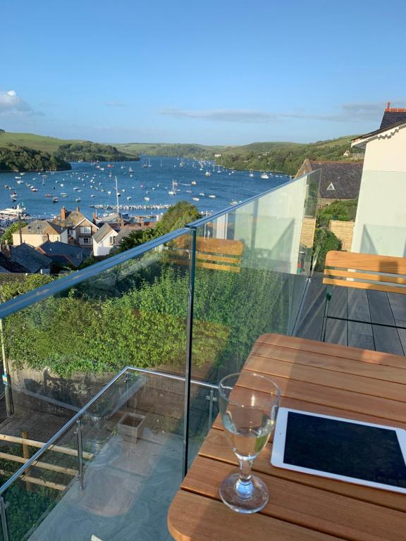 a wine glass sitting on a table on a balcony at 3, Glenthorne House, Salcombe in Salcombe