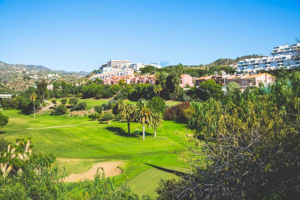 an aerial view of a golf course with palm trees at Casa para 10 personas en campo de golf Añoreta in Torre de Benagalbón