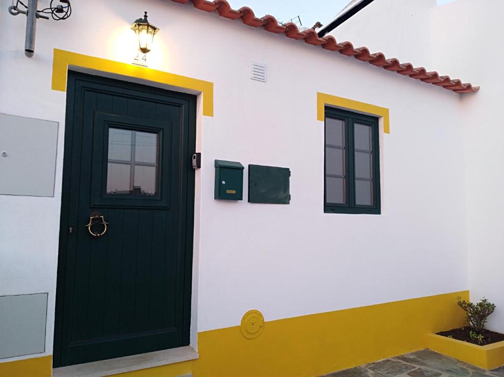 una porta verde sul lato di una casa bianca di Suão Retiro Alentejano ad Amieira
