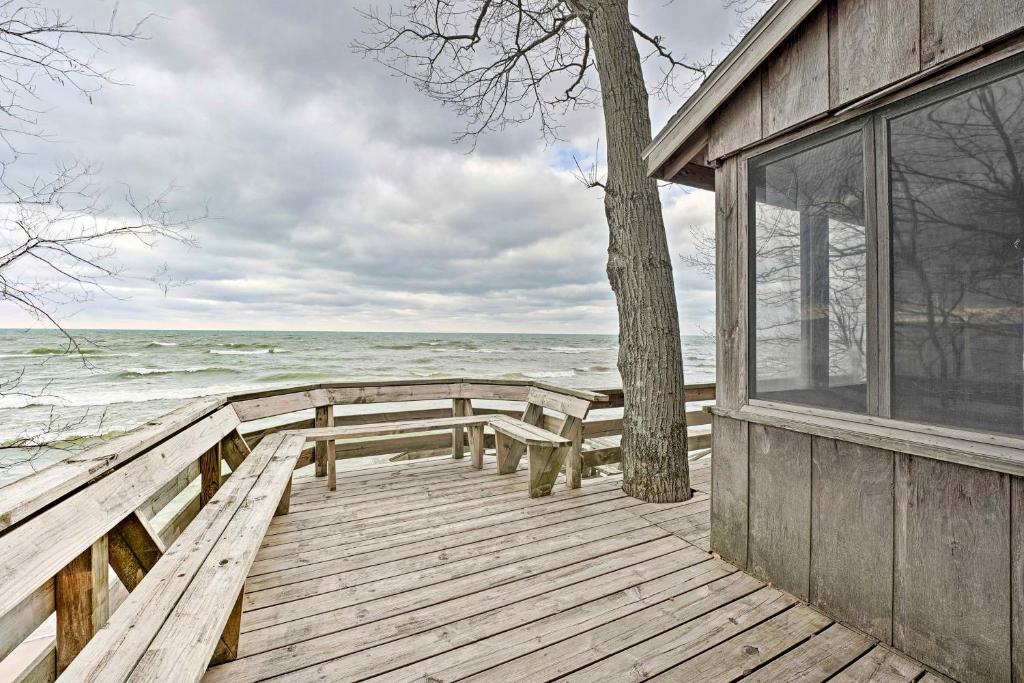 a wooden dock with a bench and a tree on the beach at Lake Michigan Waterfront Home 1 Mile to Downtown! in Douglas