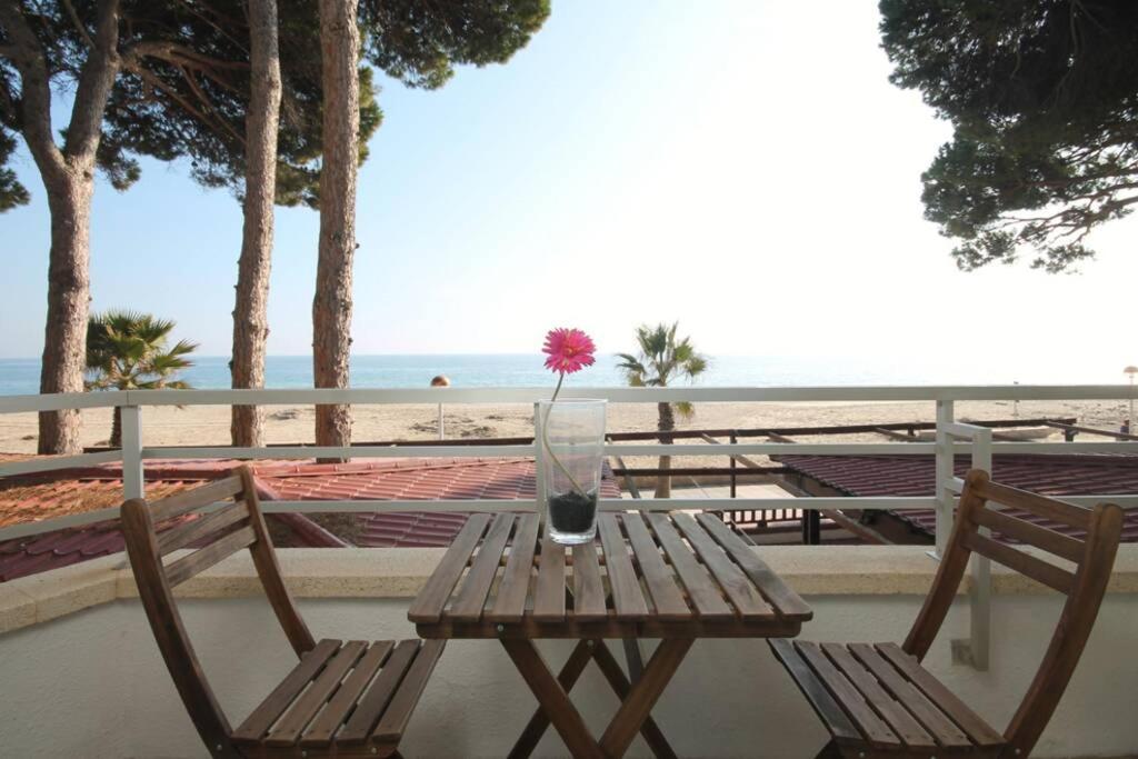 een houten tafel met een vaas met een bloem erop bij Apartamento frente al mar en Cambrils in Cambrils
