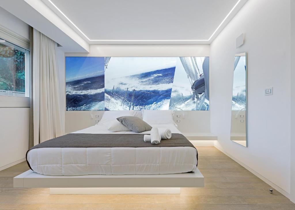ein Schlafzimmer mit einem Bett mit einem großen Gemälde an der Wand in der Unterkunft B&B Gassa D'amante in Vieste