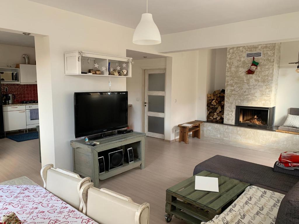 sala de estar con TV y chimenea en Апартамент “МИЛА” en Troyan