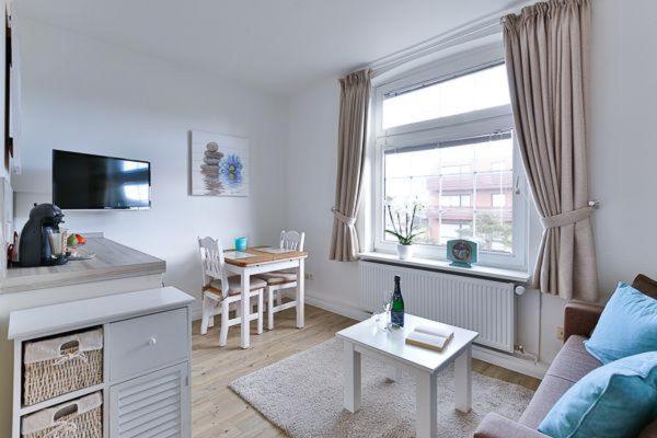 a living room with a couch and a table at App-8-in-strandnaher-Lage-Baederstil-Villa-in-Wenningstedt-Sylt in Wenningstedt