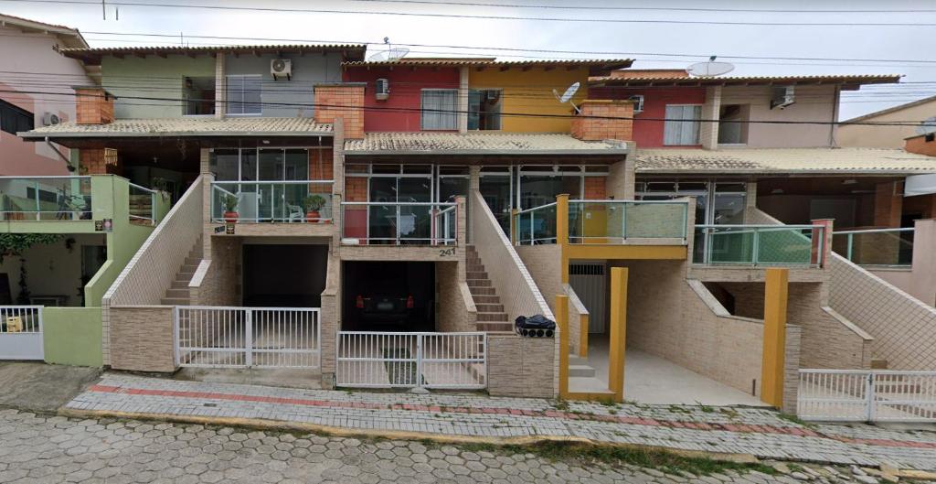 Un grupo de edificios con escaleras delante de ellos. en Sobrado 03 na Praia de Bombas, en Bombinhas