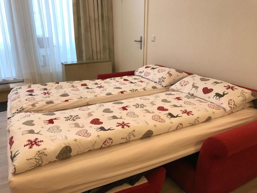 a bed with a blanket on top of it at Sport-Alpin-Wohnung-4 in Oberstdorf