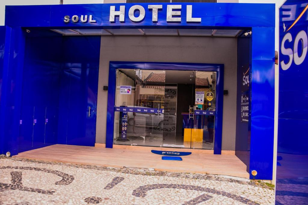otwarte drzwi do hotelu duszy z niebieską fasadą w obiekcie Hotel Soul w mieście Senhor do Bonfim