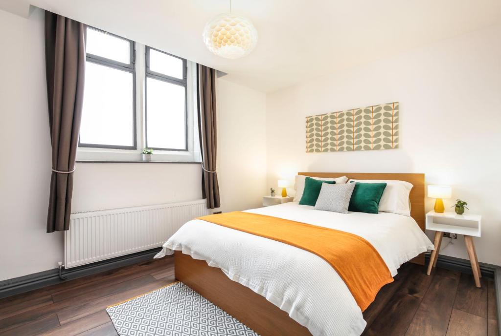 a bedroom with a bed and two windows at The Penthouses, 8 Albion Mews in Chester