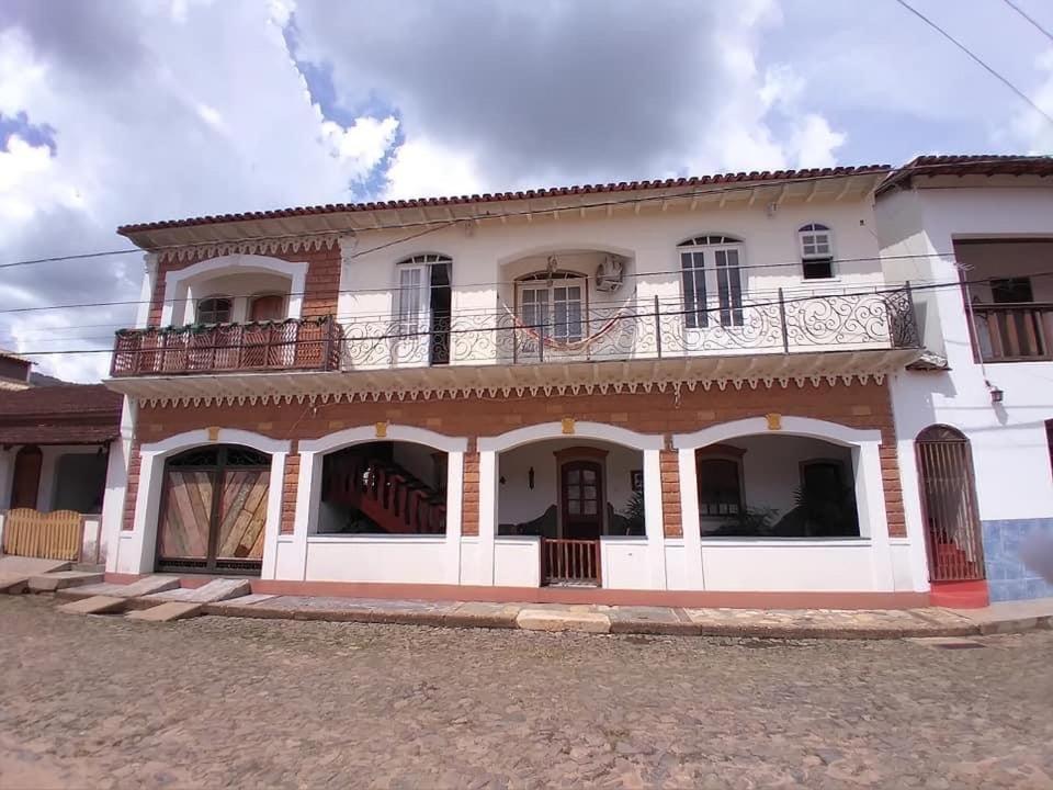 uma grande casa branca com uma varanda no topo em Casa Caminho da Serra em Tiradentes