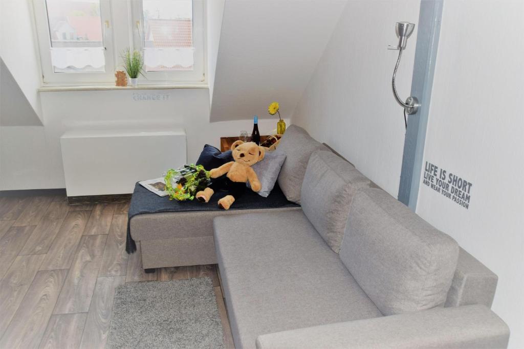 a stuffed animal sitting on a couch in a room at Turmblick-Gaestequartier-Coswig-Hier-erwartet-Sie-individueller-Service-im-Herzen-der-Altstadt in Coswig