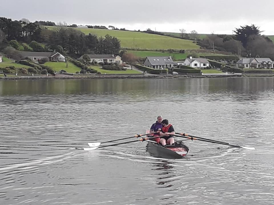 zwei Personen in einem Ruderboot auf dem Wasser in der Unterkunft Croi an Bháile Luxury Apartment in Rosscarbery