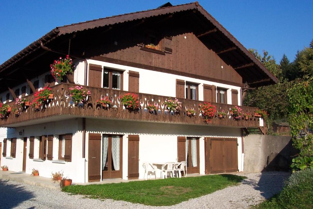 dom z balkonem z kwiatami w obiekcie GERFAUD Appartements en chalet w mieście Saint-Gervais-les-Bains