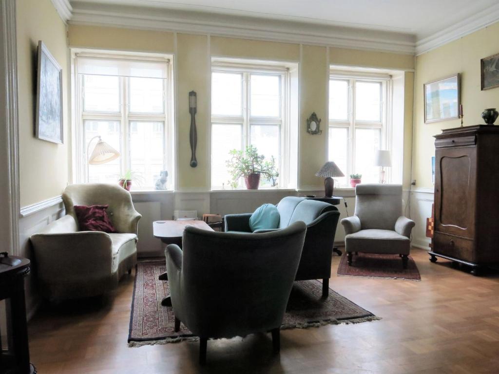 a living room with couches and chairs and windows at ApartmentInCopenhagen Apartment 980 in Copenhagen