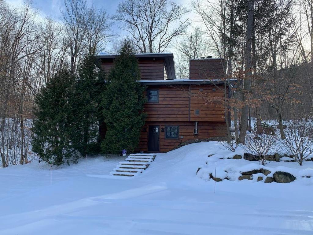 a log cabin in the snow in front at Myers Chalet in Ellicottville