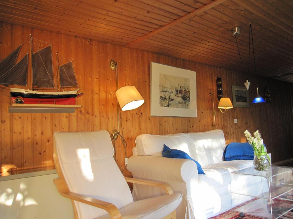 a living room with a couch and a boat on the wall at Luetjens-Bienenhaus in Ulsnis