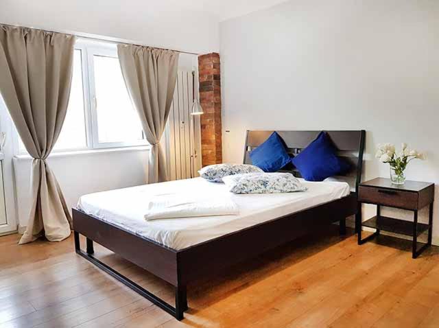 Un dormitorio con una cama con almohadas azules. en Piata Victoriei Kiseleff Studio Apartment, en Bucarest